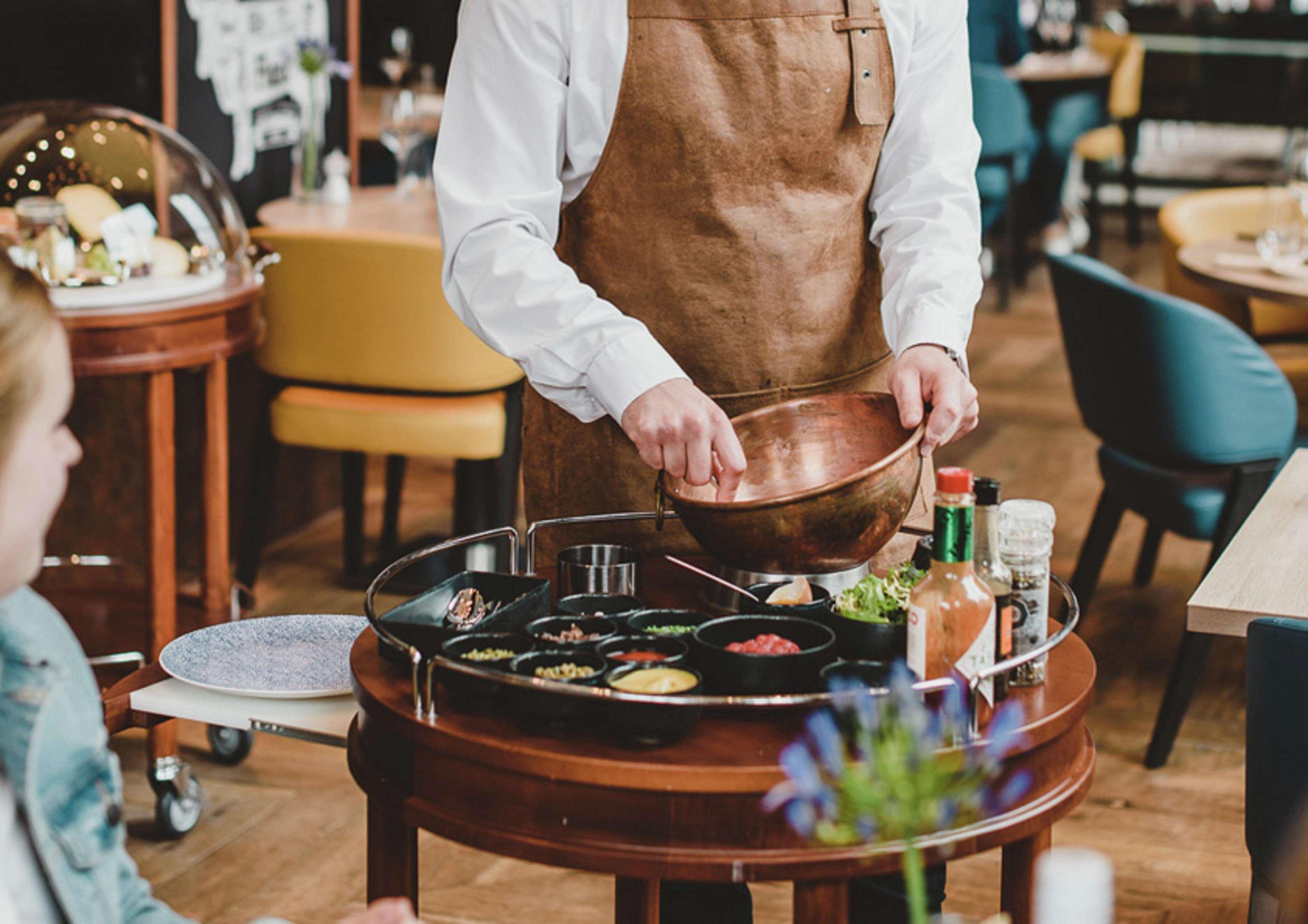 Hilton The Hague Hotel Ngoại thất bức ảnh A server prepares a dish at a restaurant